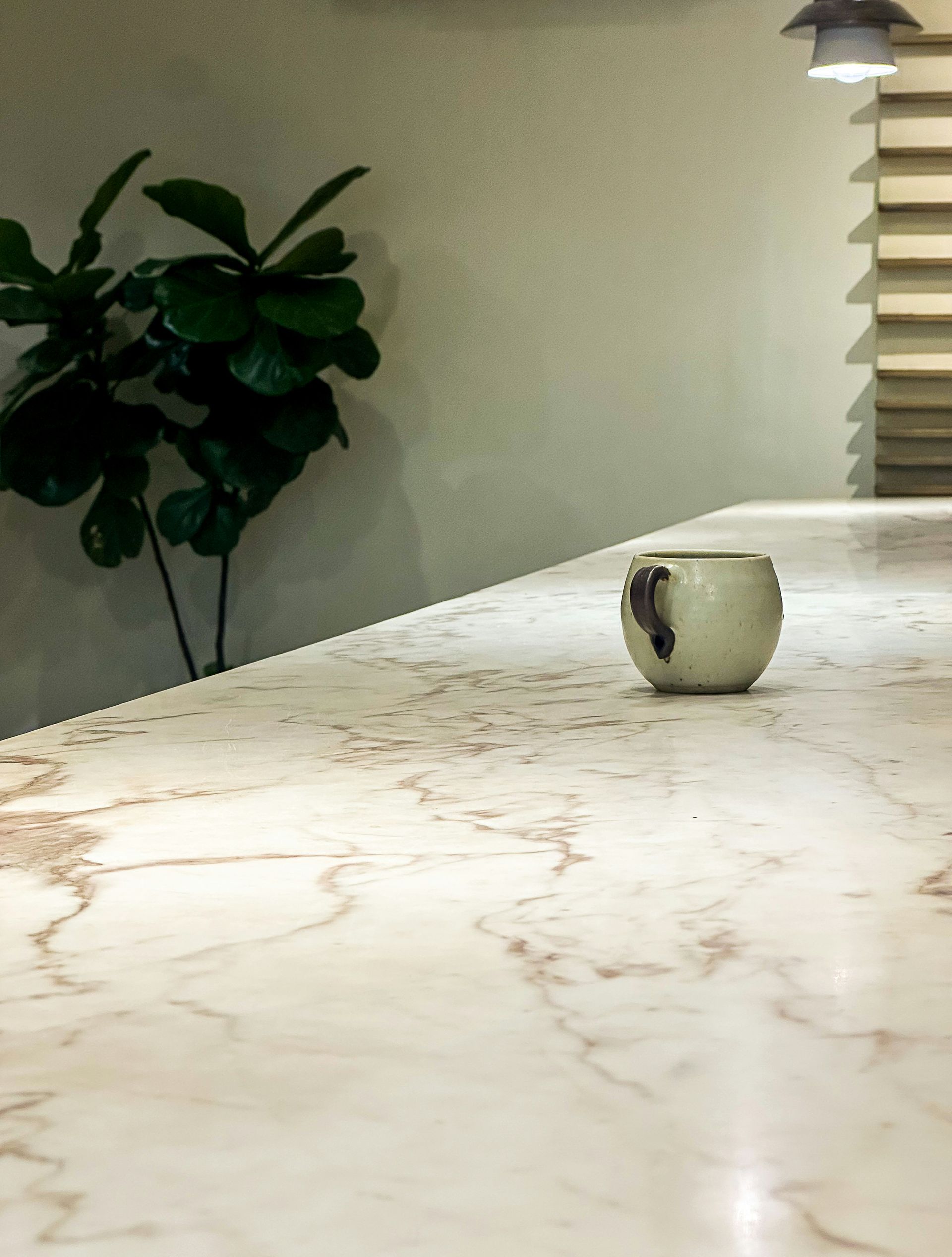 A single mug sits on a marble countertop.